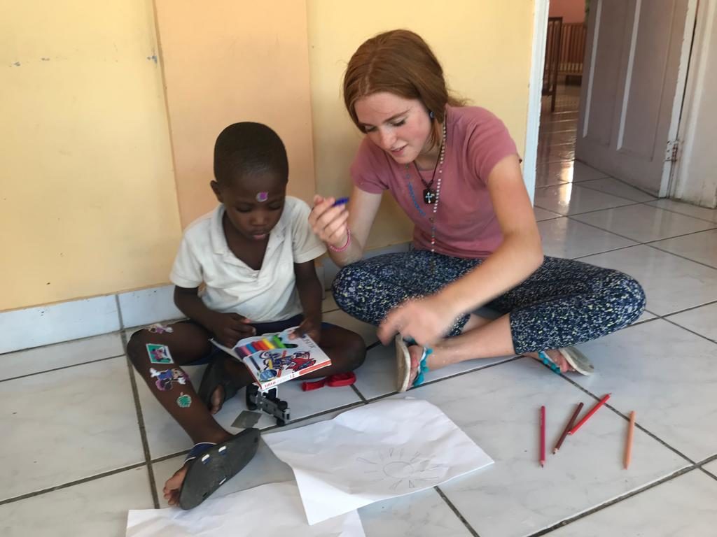 NPH service camp participant with child at NPH home