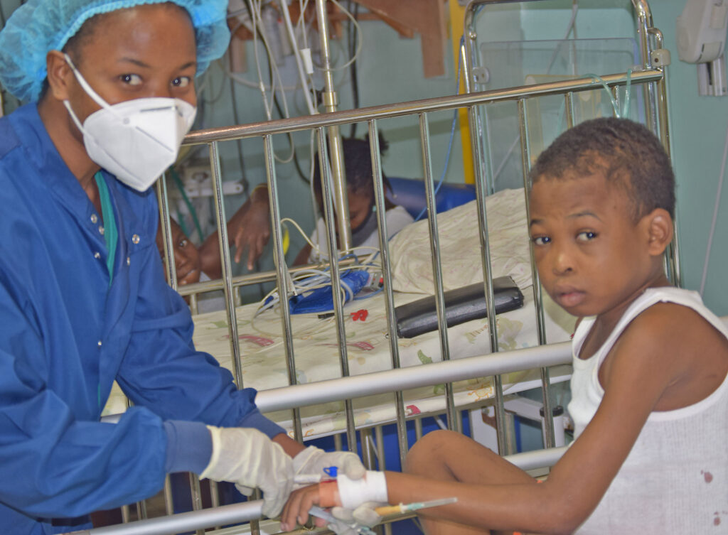 Darline with a young boy patient at St. Damien Hospital